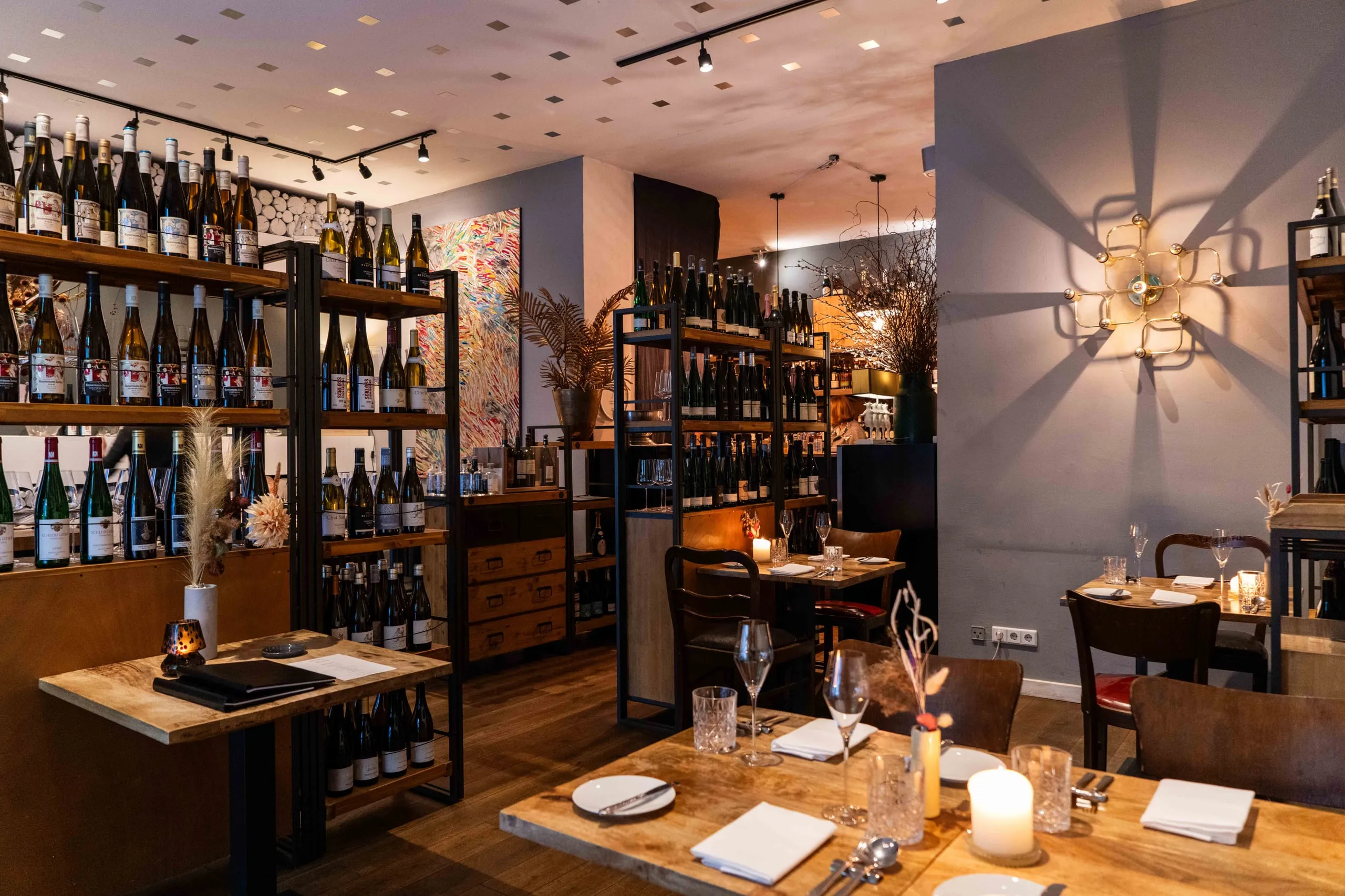Gastraum des Bricole mit Weinregal und gedeckten Tischen